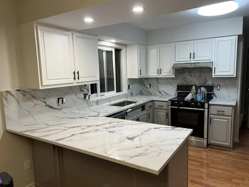 Bright kitchen with white veined countertops and matching backsplash