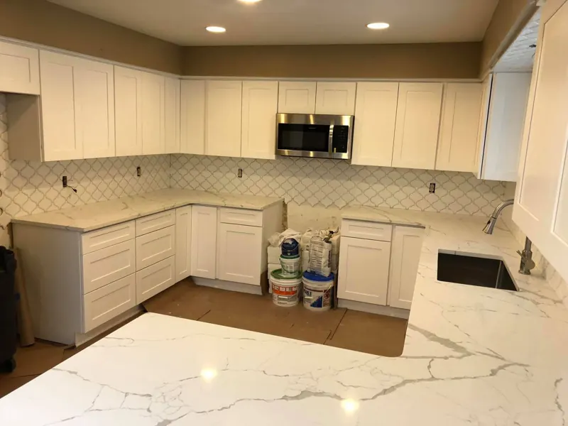 White cabinets with white veined countertops during install