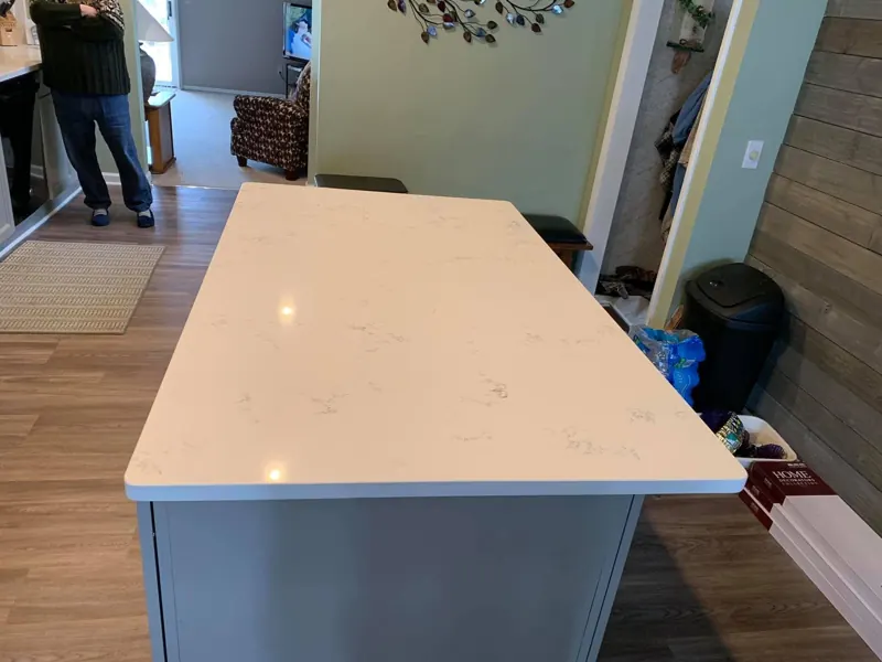 White countertop island on gray cabinets